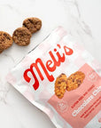 Meli's chocolate chip cookies on a marble surface with a pink packaging.