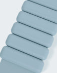 A close-up of a light blue silicone watch strap with a textured woven backing, shown against a clean white background.