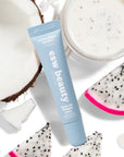 Blue tube of esw beauty cream with dragon fruit and coconut on a white background