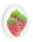 Red and green gummy candy leaves on a white plate