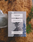 Juniper Ridge tea packaging with tea bags on a wooden surface