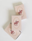 Three beige rectangular boxes arranged diagonally on a white background, each printed with a vintage-style illustration of a rider on a horse inside an oval frame.