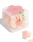Clear cube box containing gummy bears with a pink label on a white background