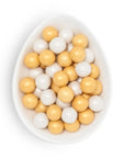 White bowl filled with yellow and white round balls on a white background
