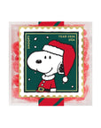 A square clear plastic package containing red, white, and green candy or gum pieces, featuring a Snoopy postage-stamp-style illustration with the text 'SNOOPY', 'YEAR 2026', and 'USA'.