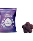 A purple bag of Tea Drops Ube Berries herbal tea drops next to a single flower-shaped dark purple tea drop on a white background.