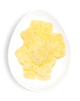 Yellow gummy bears on a white plate with a white background