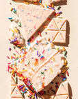 Sliced cake with colorful sprinkles on a beige background