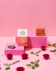 Tea packaging with a cup of tea and roses on a pink background