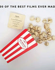 Red and white striped box with movie tickets and popcorn on a light gray background