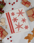 Sheet of red snowflake stamps on a white background with gift boxes and cookies.