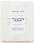 white textured journal with gold lettering that says "anniversary journal"