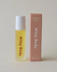 Yellow rollerball bottle with white cap and pink box on a light gray background