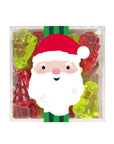 A clear square plastic box filled with colorful Christmas-themed gummy candies, including red and green bear-shaped and tree-shaped gummies, with a large Santa Claus face graphic overlaid across the center.