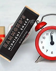Hammonds Black Midnight Snack Chocolate Bar next to a red clock on a white background