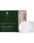 dark green shower steamer box with 4 shower steamers inside. "cedarwood & leather" is written in gold on the box