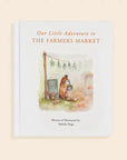 Book cover titled 'Our Little Adventure to The Farmers Market' with illustrations of animals and a market stand on a beige background.