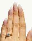 Hand wearing a gold ring with a diamond on a white background