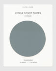 A package of Circle Sticky Notes Mykonos on a light gray background. The packaging is white with a large circular cutout showing the transparent note paper color, which appears as a muted slate blue-gray.