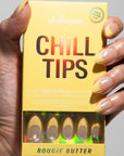 hand with french manicure press on nails with yellow tip holding yellow package they come in