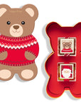 Bear-shaped candy container with red sweater design and a larger red 'X' shaped box on a white background.