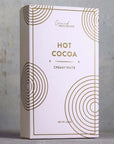 Hot cocoa packaging with gold circular designs on a gray background