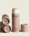 Lip balm with 'Menegold' branding on a beige background