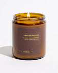 An amber glass jar candle with a lit flame, featuring a dark brown label that reads 'SALTED MOCHA' and 'P.F.