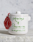 White ceramic container with 'Herbes of Provence' label on a marble surface