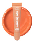 Cosmetic tube labeled 'esw beauty' on an orange background