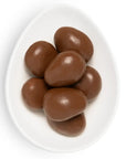 Chocolate-covered almonds on a white plate with a white background