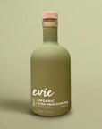 A frosted olive green glass bottle of Evie Bold Organic Extra Virgin Olive Oil with a light pink cap, set against a solid sage green background.