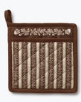 A square brown quilted pot holder with a top loop, featuring vertical striped panels in brown and cream with floral embroidery across the top border, shown on a light gray background.