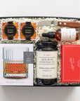Gift set with bourbon, cocktail mix, and bar tools on a white background