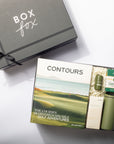Box Fox gift set with 'Contours' book and green thermos on a white surface
