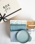 Gift set with a box, towels, and a jar on a white background