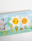 Children's book with daffodil illustrations and text on a light blue background