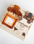 Gift set with coffee, espresso martini mix, and truffles in a box on a white background