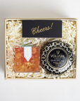 Gift box with Voluspa candle and other items on a light background