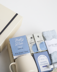 Gift set with tea packages, shower steamers, and socks on a white surface
