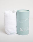 White hair towel and light blue cylindrical container with 'skön' branding on a white background