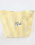Yellow striped pouch with 'Kylie' embroidery on a white background