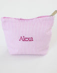 Pink striped pouch with 'Alexa' embroidered on a white background