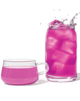 Pink drink with ice cubes in a glass and a mug on a white background