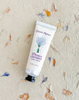 Hand cream tube labeled 'French Lavender' on a textured background with floral patterns.
