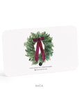 Note card with a Christmas wreath design featuring a red bow on a white background.