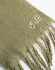 Green scarf with monogram on a white background