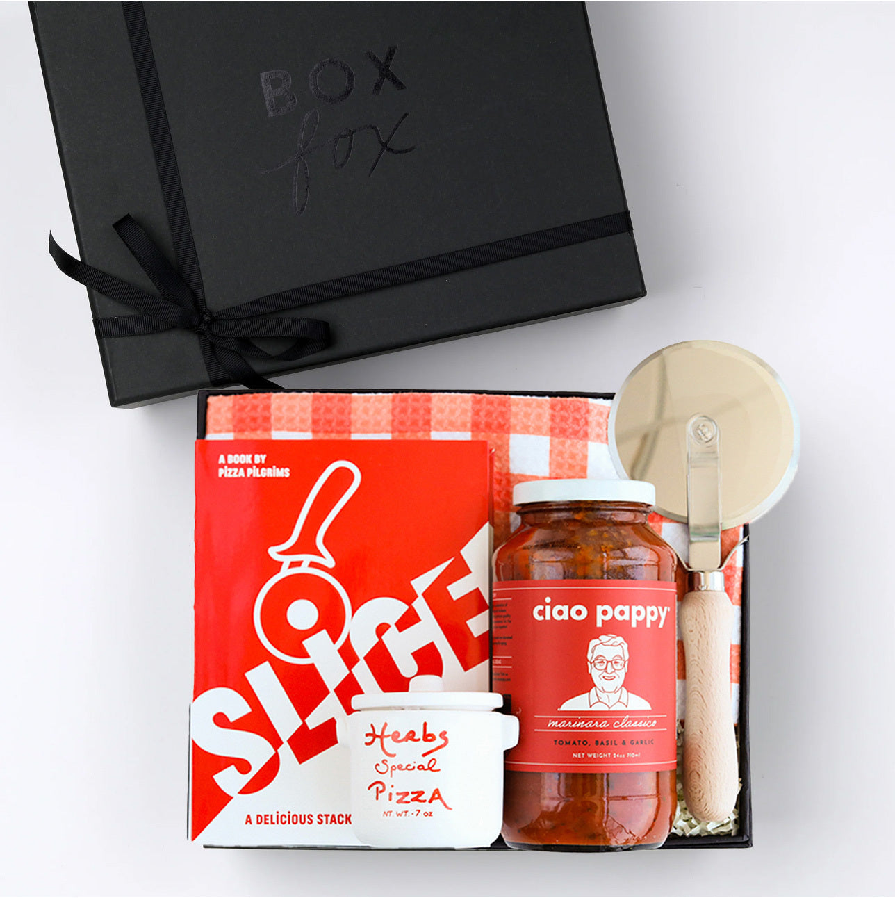 BOXFOX Black gift box packed with &quot;Slice&quot; Pizza book, wood pizza cutter, Ciao Pappy Marinara sauce, Pizza herbs jar and plaid red Geometry tea towel.