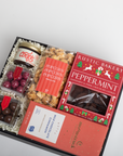 Gift box with Christmas-themed treats including peppermint cookies and popcorn.