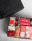 Gift box with various confectioneries and a black 'Box Fox' branded box on a light gray background